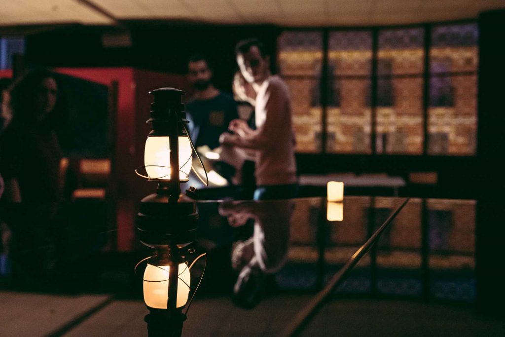 joueurs d'escape game devant une lanterne posé sur un piano